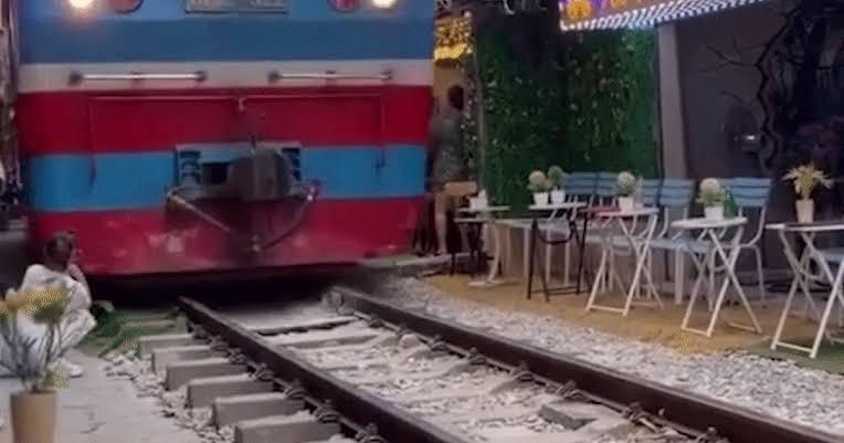 Cô gái ngồi sát đường ray ở 'phố cà phê đường tàu' bị tàu hỏa hất văng điện thoại