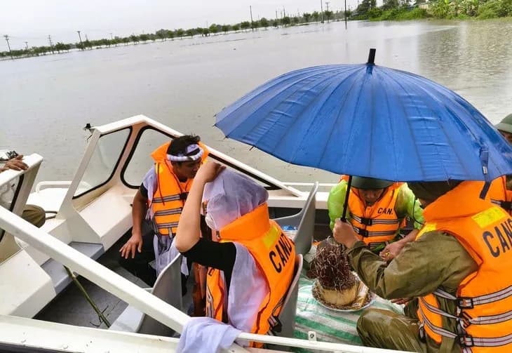 Cảnh sát dùng xuồng máy vượt lũ hỗ trợ dân đưa tro cốt về tổ chức tang lễ